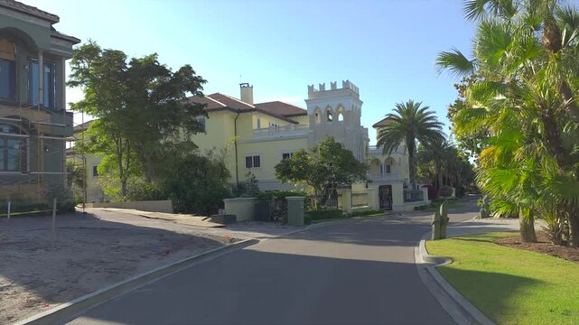 Driving on Florida scenic road. Car point of view of Casey Key coastal neighborhood with tropical nature and southern architecture.
