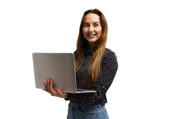 Young woman smiling while holding a laptop and standing against a plain background in a bright setting