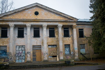 Exterior of the Baldone Sanatorium, a historic building with classical architecture and a prominent fountain.