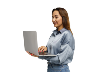 Woman works on a laptop while smiling, dressed in a stylish blue shirt in a bright environment