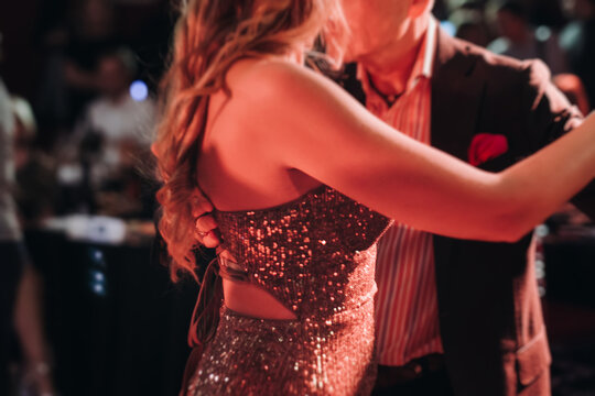 Couples dancing traditional latin argentinian dance milonga in the ballroom, tango salsa bachata kizomba lesson in red and purple lights, performance rehearsal, evening dance school class festival