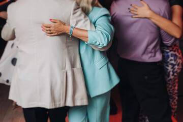 Obraz premium Couples dancing traditional latin argentinian dance milonga in the ballroom, tango salsa bachata kizomba lesson in red and purple lights, performance rehearsal, evening dance school class festival