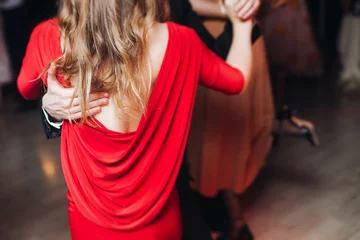 Acrylglasbilder Tanzschule Couples dancing traditional latin argentinian dance milonga in the ballroom, tango salsa bachata kizomba lesson in red and purple lights, performance rehearsal, evening dance school class festival  © tsuguliev
