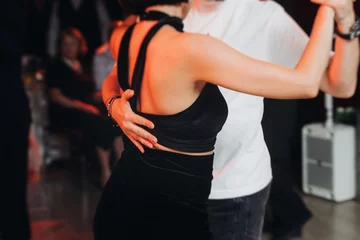 Couples dancing traditional latin argentinian dance milonga in the ballroom, tango salsa bachata kizomba lesson in red and purple lights, performance rehearsal, evening dance school class festival