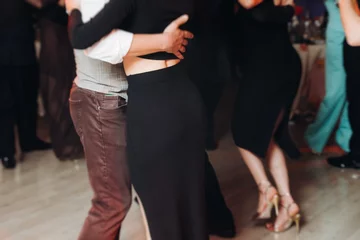 Couples dancing traditional latin argentinian dance milonga in the ballroom, tango salsa bachata kizomba lesson in red and purple lights, performance rehearsal, evening dance school class festival