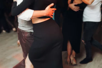 Couples dancing traditional latin argentinian dance milonga in the ballroom, tango salsa bachata kizomba lesson in red and purple lights, performance rehearsal, evening dance school class festival