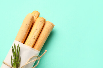 Bunch of tasty Italian Grissini on turquoise background, closeup