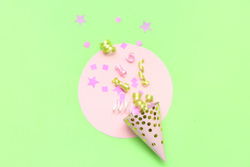 Composition with party hat and confetti on green background