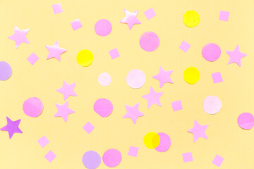 Composition with confetti and stars on yellow background