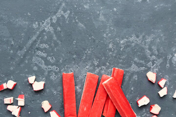 Tasty cut and whole crab sticks on green background © Pixel-Shot