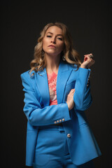 a beautiful blonde in a blue pantsuit. black background