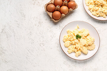 Composition with plates of scrambled eggs on light textured background