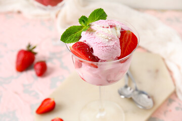 Glass of strawberry ice cream with mint on grunge table, closeup