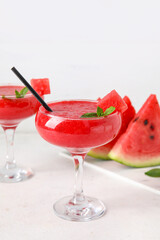 Glasses of tasty watermelon juice with mint on white table