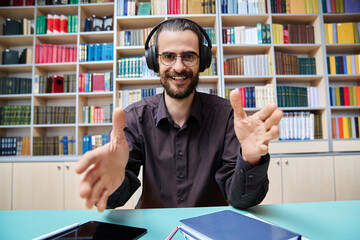 Webcam view young talking man making video call chat conference, in library