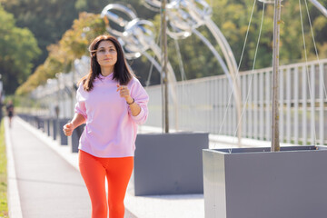 young woman on a summer run in a city park