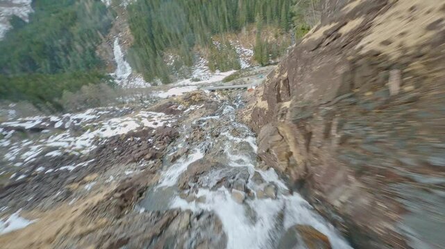fpv drone diving spectacular Latefossen waterfall in Norway and flying under road bridge on a spring day