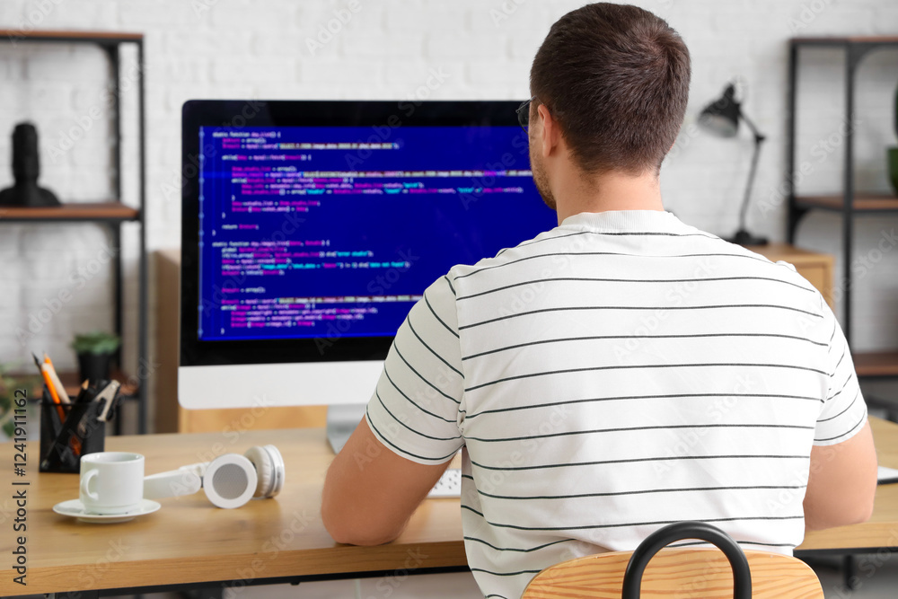 Wall mural male programmer working with computer in office, back view