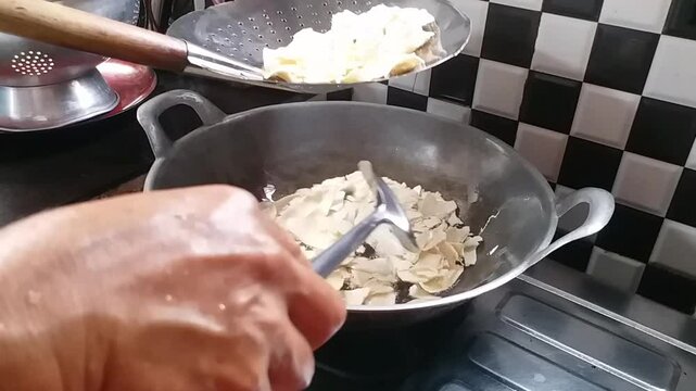 Process Deep Frying Crackers in the Hot Oil, Kitchen Step by Step. Goreng Kerupuk, Indonesian Crackers