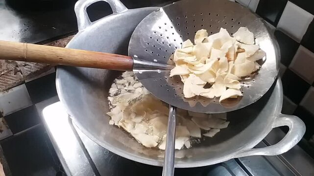 Process Deep Frying Crackers in the Hot Oil, Kitchen Step by Step. Goreng Kerupuk, Indonesian Crackers