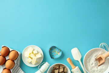 Baking ingredients on a blue background: eggs, butter, milk, sugar, flour, and sprinkles. Perfect for food blogs, recipe websites, and culinary content