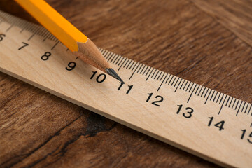 Ruler and pencil on wooden table, closeup