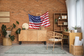 Stylish room with chest of drawers and USA flag on brown brick wall