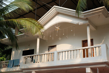 Fototapeta premium Two-story house with a balcony, decorated with hanging Christmas star ornaments