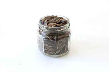 白背景のガラス瓶にいれたヒマワリの種