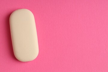 One eraser on pink background, top view. Space for text