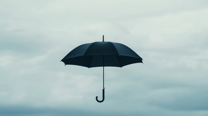 Black umbrella floats, cloudy sky, weather protection concept