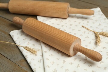 Rolling pins, spikes and napkin on wooden table, closeup