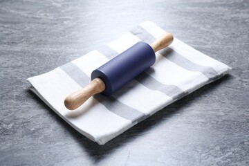 Rolling pin on grey textured table, closeup