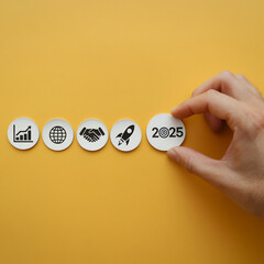 Achieve Your Business Goals: 2025 Vision. Wooden blocks, graphs, teamwork, rocket, and a hand setting the 2025 target. Success planning, future strategy,       