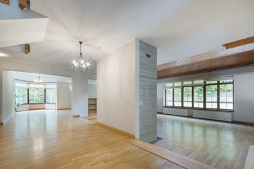 A spacious room with parquet floors and large windows in a luxurious mansion. Unfurnished.