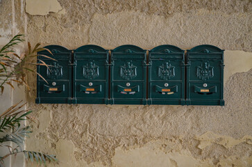 green mailboxes on the wall of a tenement house in Syracuse