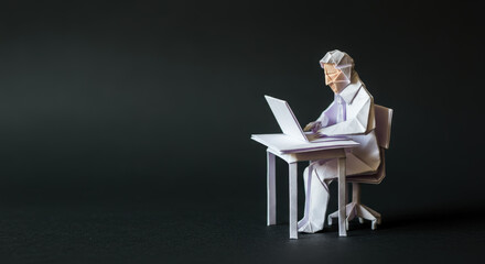 Naklejka premium Scientist made of origami working diligently in a research lab at a desk with a laptop computer, focused on the task at hand