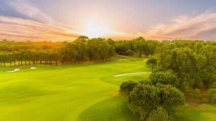 A serene sunset view of a golf course surrounded by lush greenery