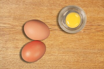 Cracked and whole fresh chicken eggs on desk