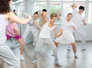 Group of boys and girls rehearsing hip hop dance in studio