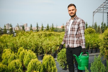 Fototapeta premium With watering can. Gardener is at work at daytime