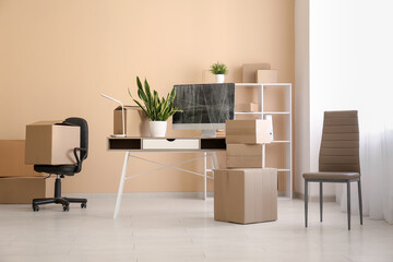 Workplace with cardboard boxes and chairs in office on moving day