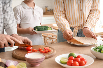 Little boy with his parents cooking Fajita in kitchen, closeup