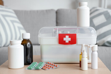 First aid kit with medicines on table in living room