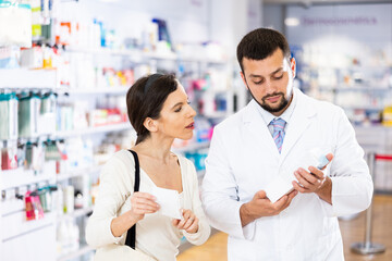 Fototapeta premium Woman asking questions about medicine during consultation with man druggist.