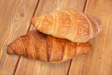 Freshly baked tasty sweet croissant on desk