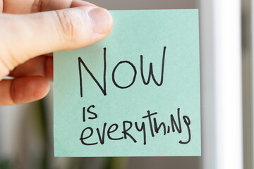 Sticky Notes with 'Now is Everything' on Colored Paper