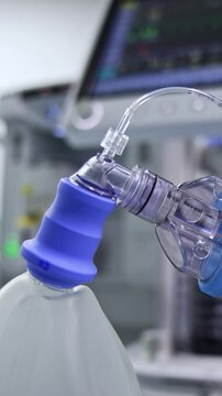 Thick tubes connected to inflating ambu bag. Close up. Lung ventilator machine working at blurred backdrop. Vertical video