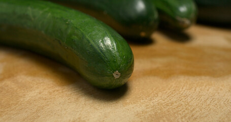 Close-up of tip of European cucumber on a wooden table
