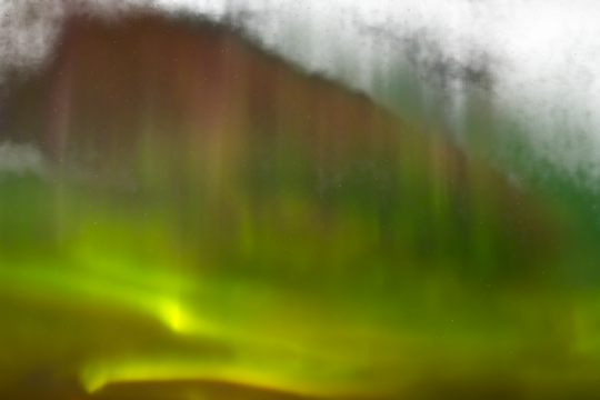 Multi-colored Northern Lights Aurora arcing across a starry night
